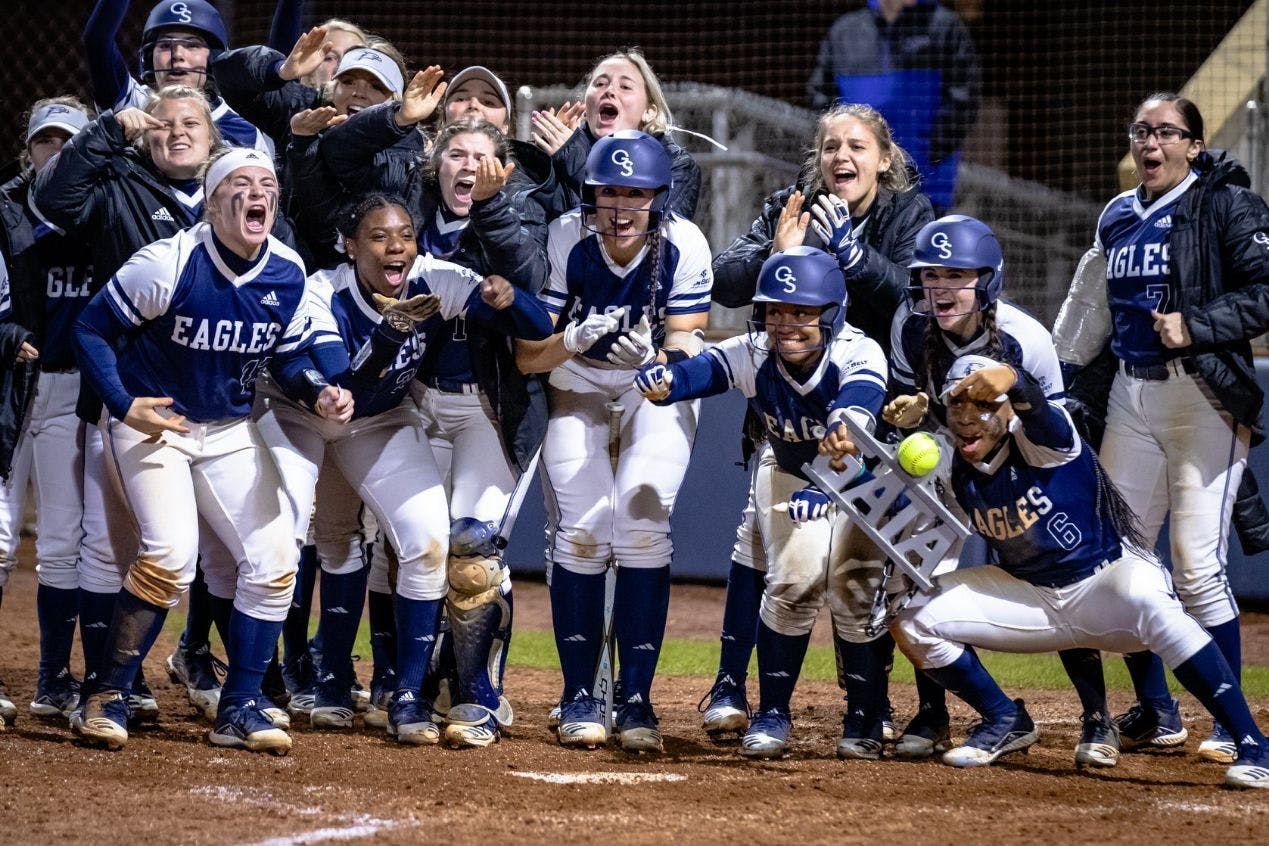 Georgia Southern University softball team celebrating at the plate after a home run